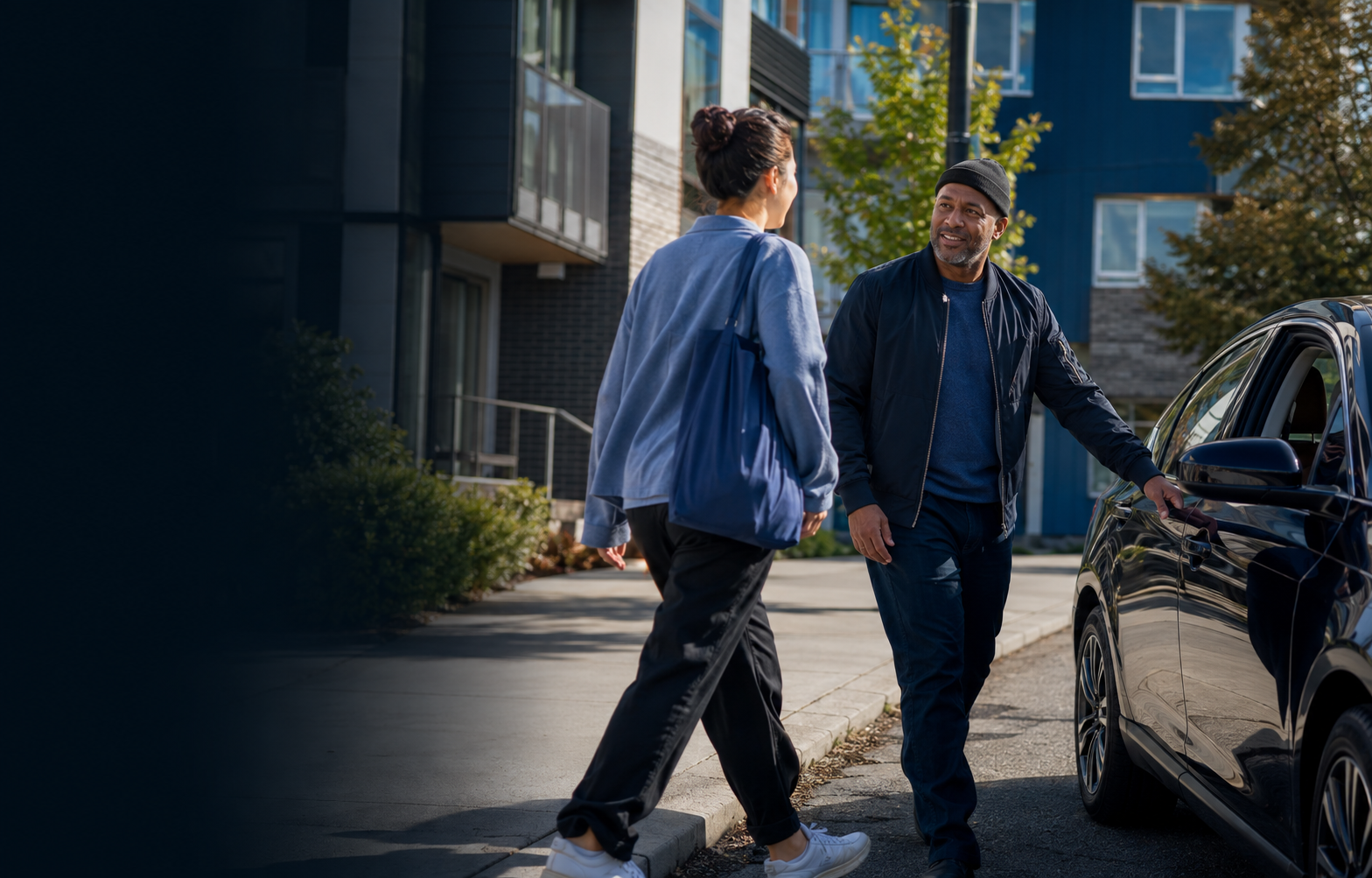 A RideOn driver welcomes a rider beside a waiting car